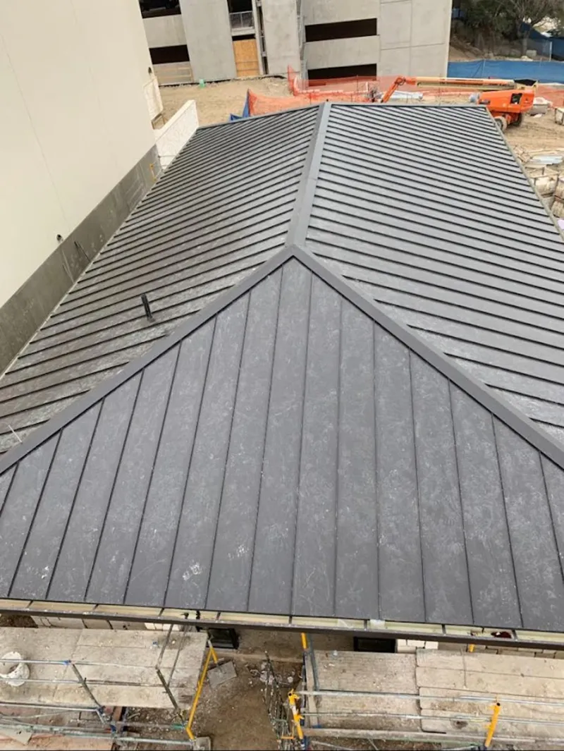 Commercial metal roof construction with crane equipment in Lahaina